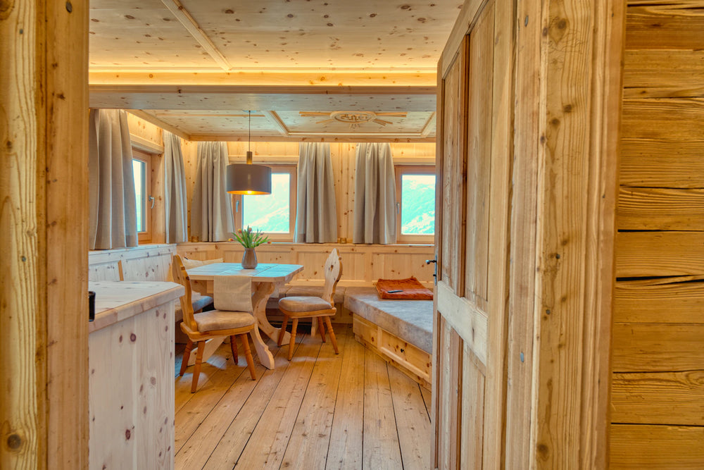 Un intérieur lumineux en bois, avec une table et un coin salon — photographie d’ambiance de Dominik Neuner.